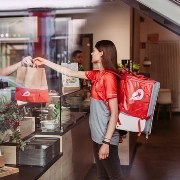 Delivery worker receiving the order at a cafe.