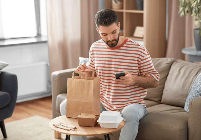 Man opening up a bag with a takeaway order.