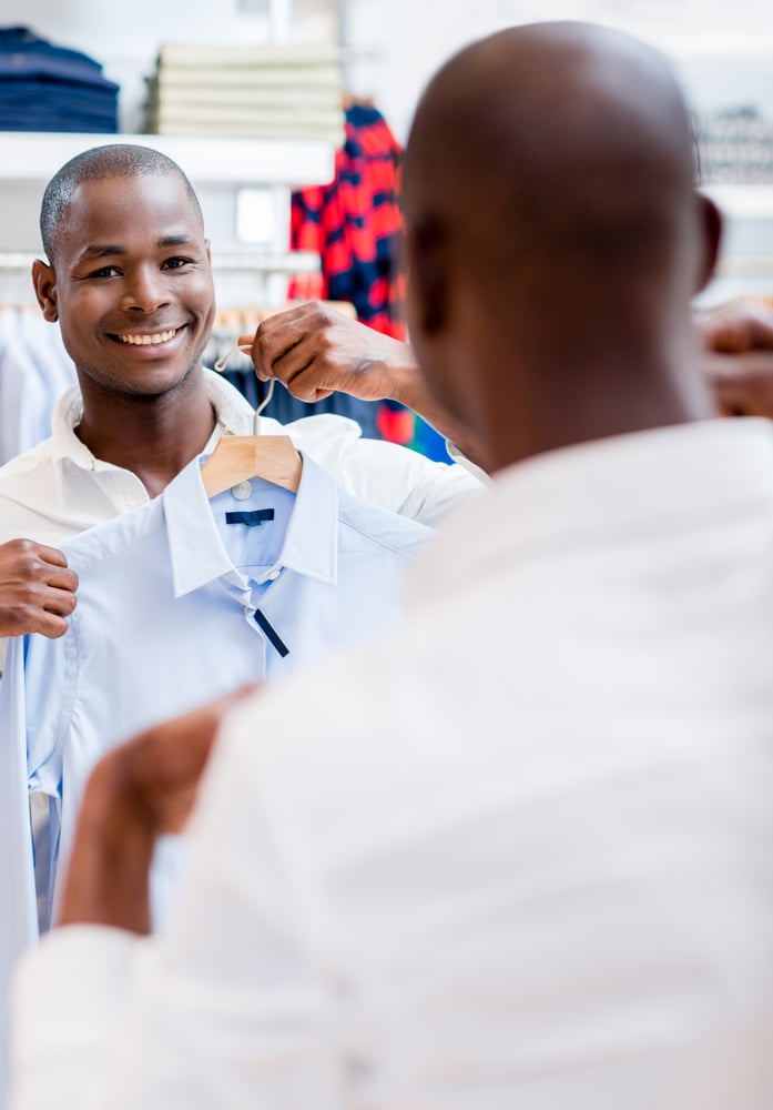 Happy shopping man trying on some clothes