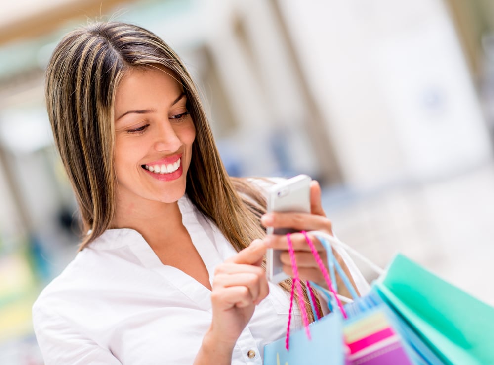 Happy woman using cell phone at a shopping center-1