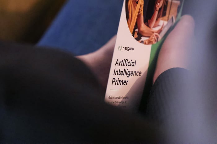 Person holding a leaflet that says "AI Primer"