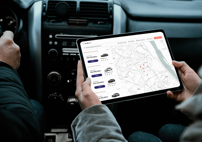 A person holding an ipad with a car marketplace site on.