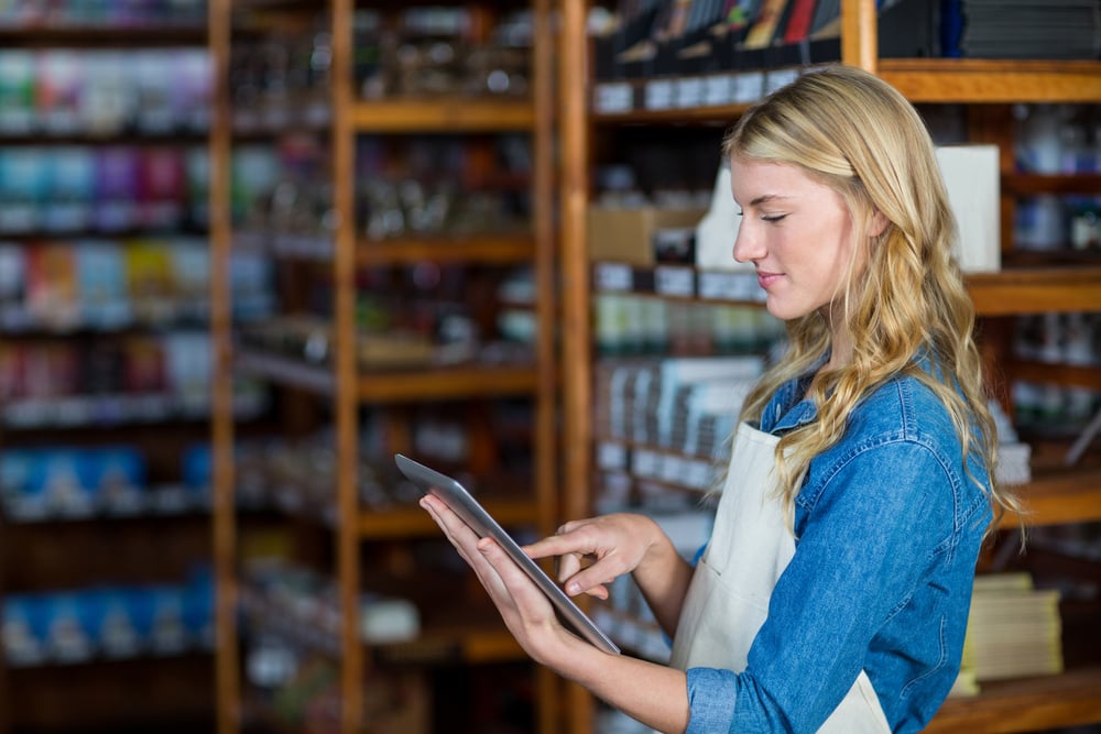 Smiling female staff using digital tablet in supermarket-2