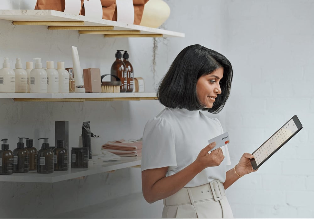 Woman in a shop holding a payment card and a tablet