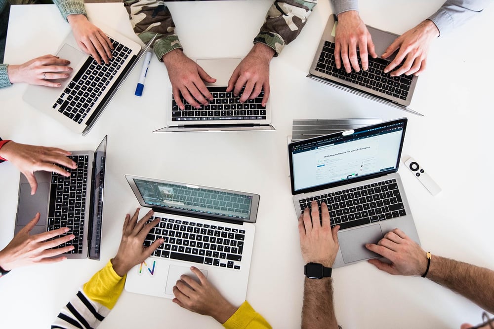 Hands typing on laptops