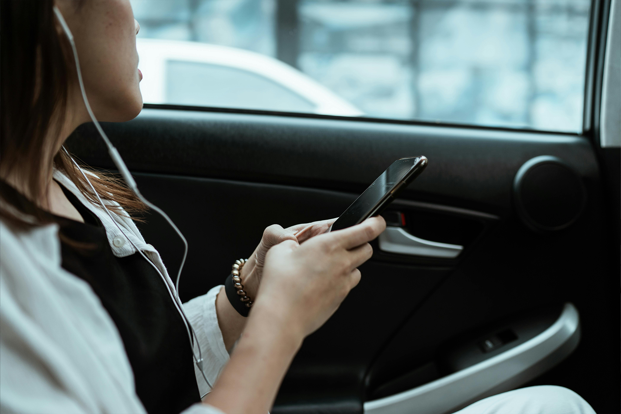 A woman texting in the car.