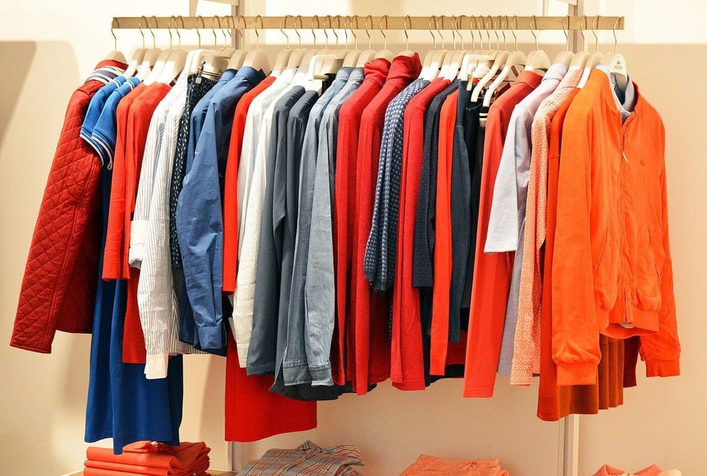 assortment of clothing items on hangers