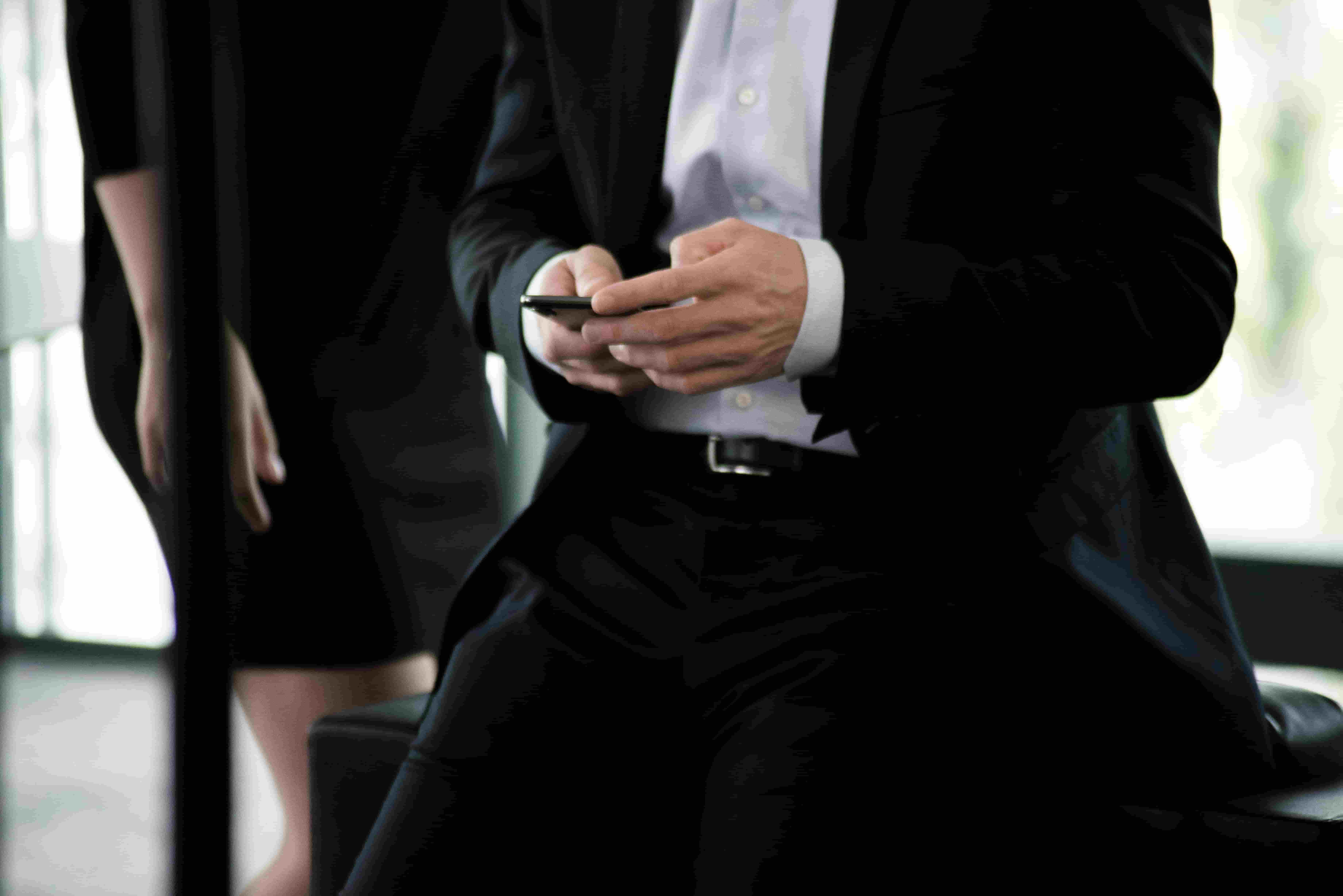 mid-shot of a man in a suit using a phone